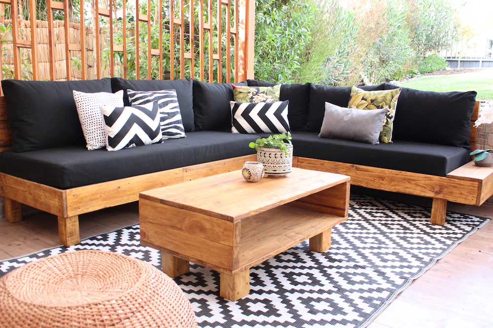 terraza_linda_de_madra_de_pallets_y_cojines_negros.jpg