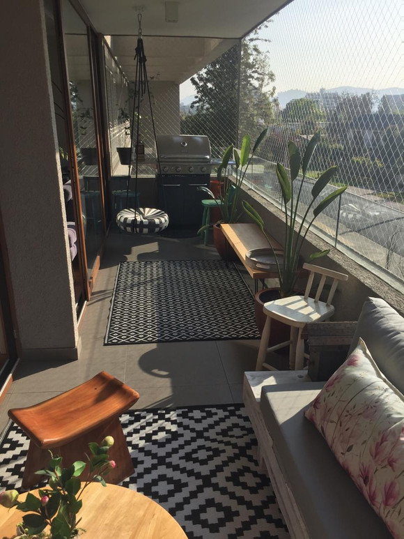 Terraza larga con sector de living y de parrilla