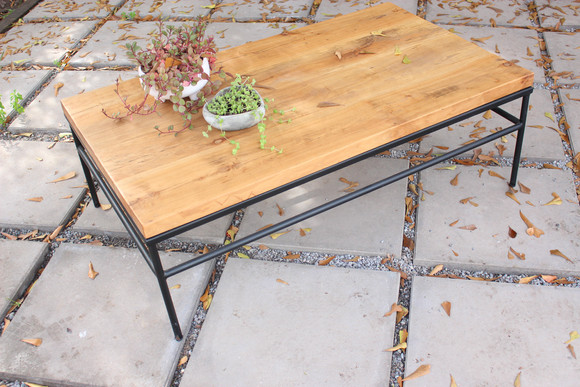 Mesa de fierro de perfil circular y cubierta de madera