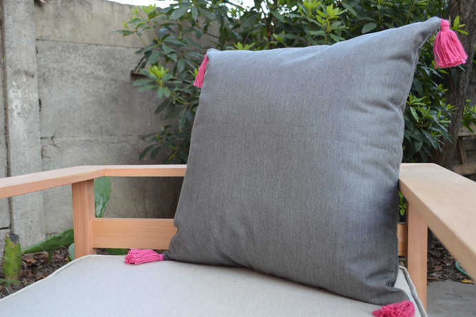 Cojín decorativo de exterior premium de 50 por 50 cm - cojin tela de exterior ris con flecos rosados.jpeg